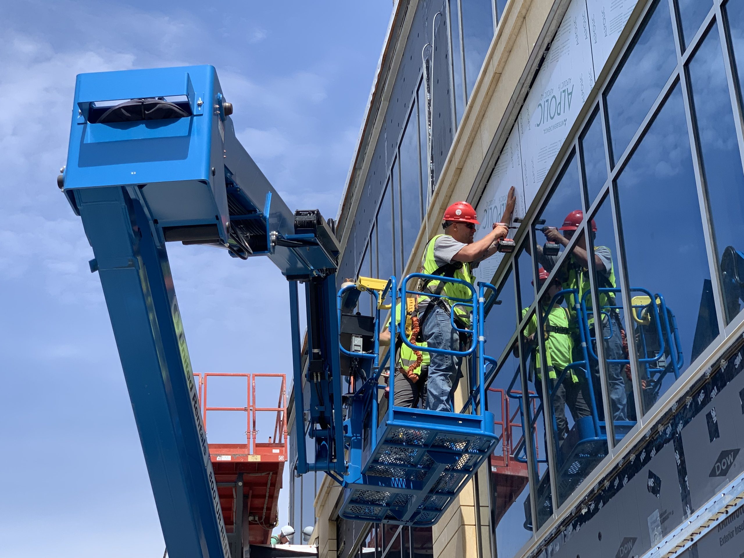 Schwickert's architectural metal installer installing metal panel on side of building