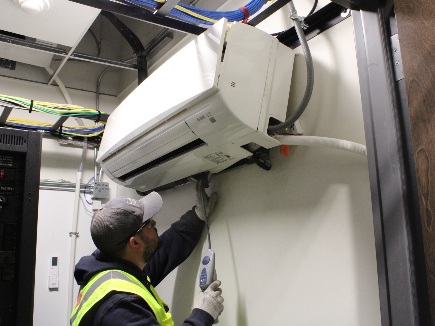 commercial HVAC-R tech doing maintenance on commercial HVAC unit