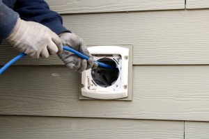 tech cleaning dryer vent at residential home